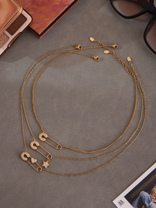 Dettaglio della collana a graffetta dorata con ciondoli a stella e cuore brillanti