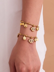 Close-up of double-layer gold puppy bracelet set with sparkling zircon paw and heart charms