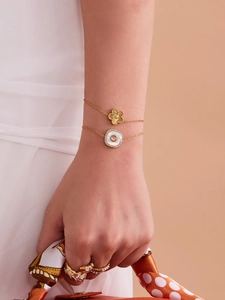 Détail de bracelets trèfle en or 18 carats et bagues en diamant sur le mannequin