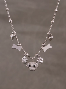 Macro detail of puppy pendant with pavé zircon stones and charms on beaded chain