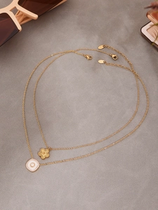 Détail du collier floral doré à deux rangs avec pendentif fleur et zircons brillants