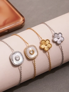 Vue détaillée de quatre bracelets trèfles en or et argent sur un présentoir