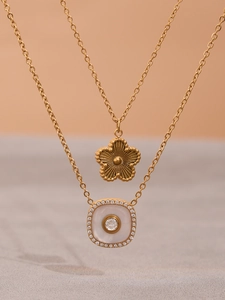Détail de pendentifs fleur et carré plaqués or 18 carats avec zircon et nacre incrustée