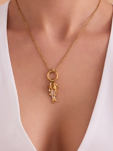 Détail de breloques étoile de mer et poisson dorées 18K sur un collier à fermoir rond