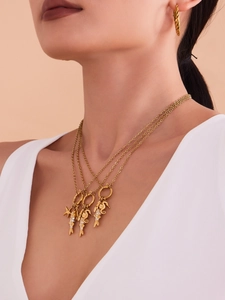 Gros plan d'un collier à trois rangs plaqué or 18 carats avec pendentifs hippocampe et poisson