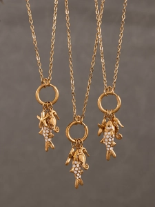 Détail des breloques poisson, hippocampe et étoile de mer en plaqué or 18 carats sur chaîne