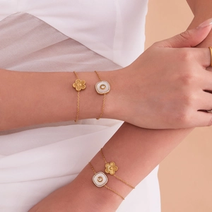 Ensemble de bracelets trèfle à cinq pétales en acier doré 18 carats sur un modèle