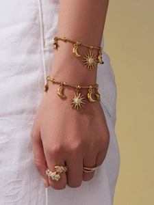 Détail de bracelets soleil lune et étoile plaqués or 18k sur poignet de mannequin