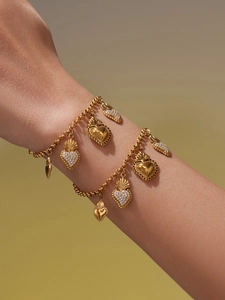 Vue détaillée d'un bracelet doré vintage avec pendentifs Sacré-Cœur et cristaux brillants