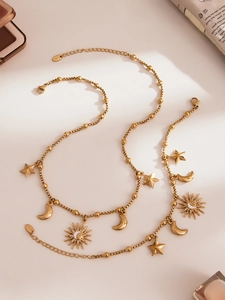 Détail des pendentifs soleil et lune en acier inoxydable doré avec une chaîne à billes
