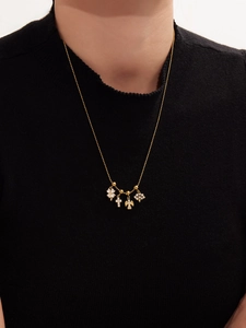 Dettaglio della collana placcata oro 18k con quadrifoglio, croce, angelo e fiocco