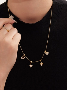 Dettaglio della collana dorata con pendenti in zircone e anello su modella donna