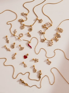 Dettaglio di ciondoli placcati oro 18k con cuore, peperoncino e albero della vita e zirconi