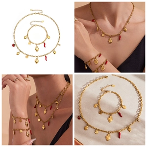 Macro shot of stainless steel gold jewelry set with heart and cornicello chili charms