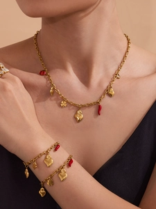 Golden necklace and bracelets set with heart and ladybug charms on model