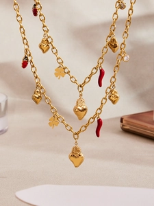 Detail of gold-plated charm necklace with red enamel chili, ladybug, and clover charms