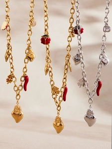 Detail of gold and silver heart crown bracelets with red chili and ladybug charms