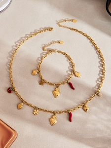 Detail of gold stainless steel necklace and bracelet set with colorful heart and clover charms