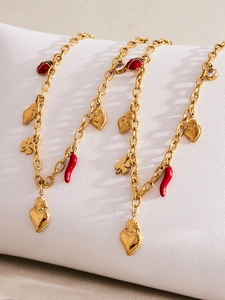 Detail of gold stainless steel bracelet with enamel ladybug, heart and chili charms