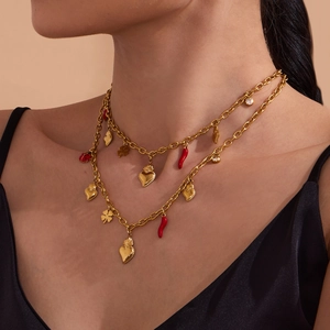 Double-layer gold chain necklace with heart, chili, and clover pendants on model