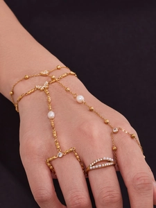 Gros plan du bracelet bague plaqué or avec motif papillon, perles et cristaux fins