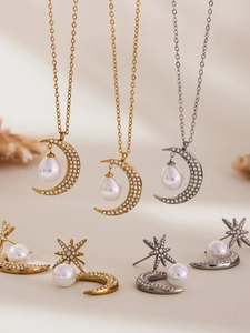 Dettaglio della collana con luna e orecchini a stella con zirconi e perle
