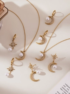 Set dettagliato di gioielli placcati oro con accenti di luna, stelle e perle