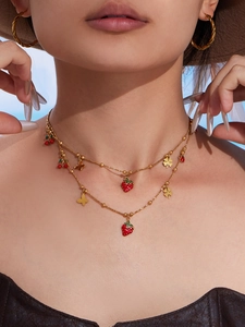 Dettaglio collana a strati oro 18k con ciondoli a ciliegia e fragola smaltati su modella