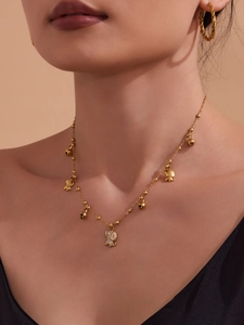 Détail d'un collier plaqué or 18 carats avec chien en zircon 5A et breloques cloche