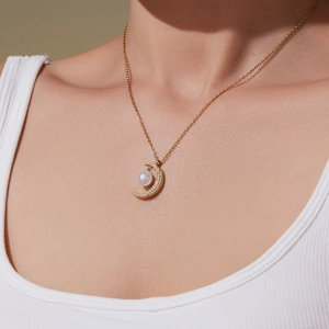 Collana a mezzaluna dorata con perla e zirconi indossata da una modella