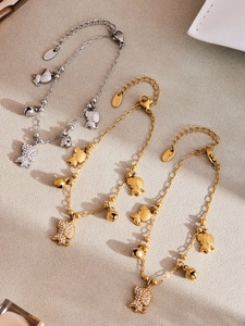 Détail de bracelets à breloques en acier avec pendentifs chien et zircons scintillants