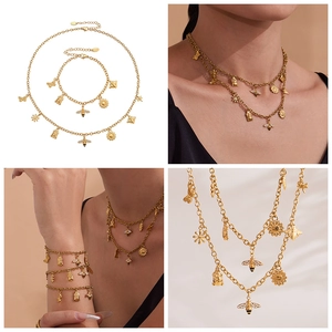 Detailweergave van de gouden roestvrijstalen ketting met zonnebloem en bijenhangers