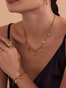 Detail van gouden bijen-sieradenset met ketting en ringen gedragen door een model