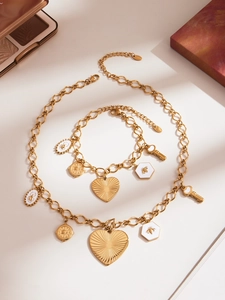 Détail du collier et bracelet en acier inoxydable doré avec plusieurs pendentifs