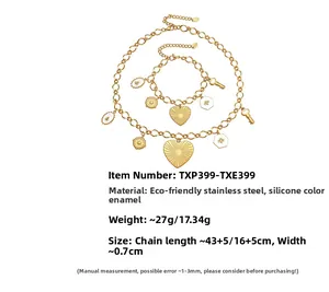 Parure dorée en acier inoxydable avec pendentifs cœur, abeille et clé sur fond blanc