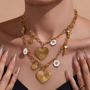 Collier double couche en acier doré avec charms cœur, abeille et pièces sur un mannequin