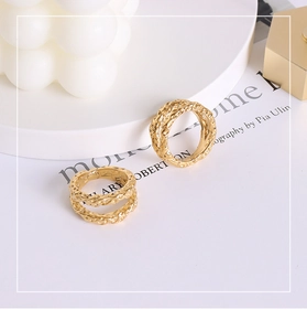 Detailed view of two gold hammered texture rings with irregular vintage industrial design
