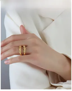 Close-up of golden ring with hammered texture worn with a white professional blazer