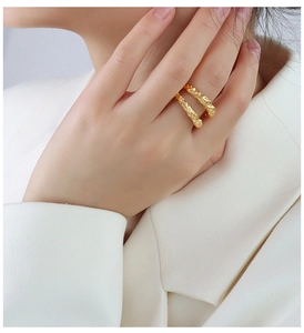 Detail of double-layer hammered gold ring with lava texture finish on a model