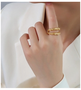 Close-up of a double-layered 18K gold ring with irregular lava texture on a model hand