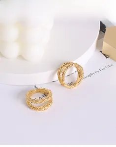 Detailed view of two 18K gold plated titanium rings with a hammered lava texture