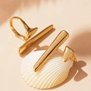 Minimalist gold geometric T-bar open ring set on white shell with mirror finish