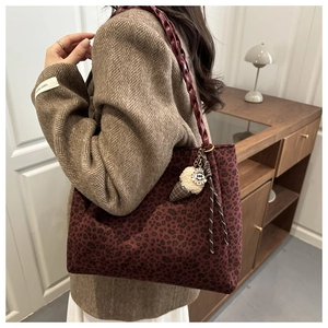 Detail of leopard print tote bag with woven handle and creative plush ice cream charm