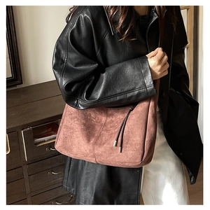 Detail of suede hobo bag in vintage rose with decorative side drawstring for casual wear