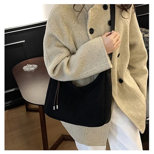Close-up of minimalist black hobo bag in matte suede fabric with brown string detail