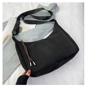 Dettaglio della borsa hobo nera opaca con tracolla regolabile e tiretto della zip decorato