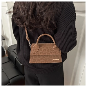 Détail du sac léopard en daim avec logo doré et bandoulière réglable chic