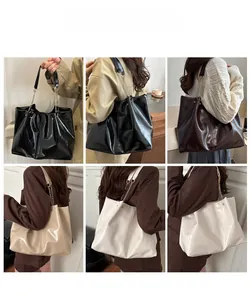 Detail view of large leather tote bags in black, brown, and beige with chain straps