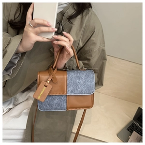 Detail of contrast patchwork small square bag featuring wool and brown leather textures