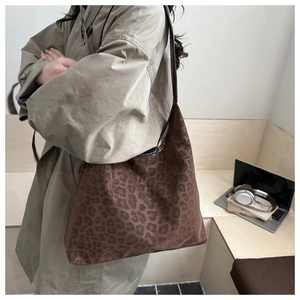 Détail d'un grand sac cabas léopard avec bandoulière porté par une femme en trench